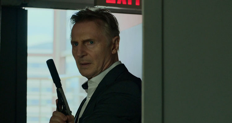 Memory 2022 Movie Scene Liam Neeson as Alex Lewis holding a gun with a silencer