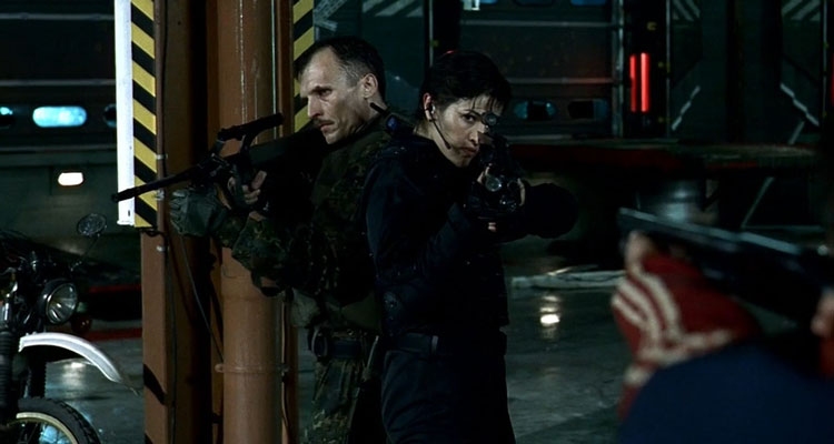 The Nest AKA Nid De Guepes 2002 Movie Scene Richard Sammel as Winfried and Nadia Farès as Helene holding their weapons inside the warehouse