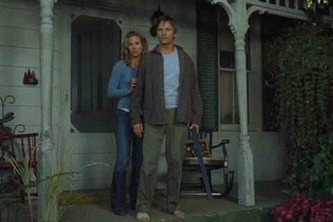 A History of Violence 2005 Movie Scene Viggo Mortensen as Tom Stall holding a shotgun in front of his house with Maria Bello as Edie standing next to him