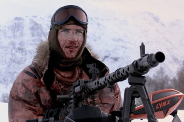 Dead Snow 2009 Movie Lasse Valdal as Vegard firing a German heavy machine gun MG 32 mounted on top of his snowmobile