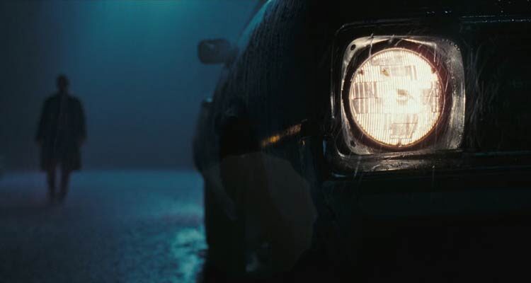 The Hitcher 2007 Movie Scene The headlights of a car with a dark figure of a man in the background