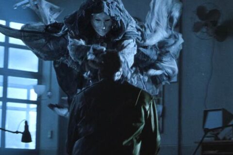 Darkness Falls 2003 Movie Scene The tooth fairy with a porcelain mask and a black cape killing one of the cops in a police station