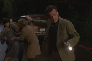 Dead End 2003 Movie Scene Ray Wise as Frank shining a light to a dead body on the road while the rest of the family is in the back
