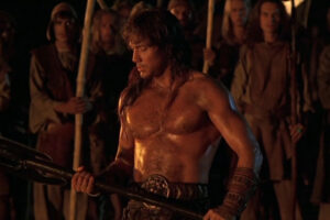 Kull The Conqueror 1997 Movie Scene Kevin Sorbo as Kull showing his muscles and holding a big axe