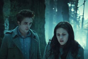 Twilight 2008 Movie Scene Robert Pattinson as Edward Cullen stalking Kristen Stewart as Bella Swan in a forest