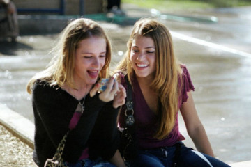 Thirteen 2003 Movie Nikki Reed as Evie Zamora and Evan Rachel Wood as Tracy Freeland looking at new tongue piercing in a mirror and laughing