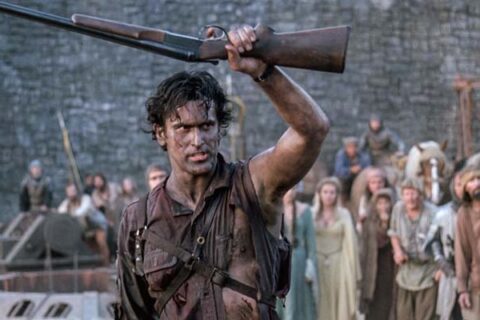 Army of Darkness 1992 Movie Scene Bruce Campbell as Ash showing his shotgun he calls boomstick to the villagers