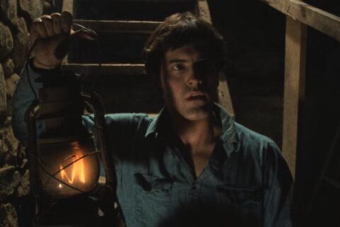The Evil Dead 1981 Movie Scene Bruce Campbell as Ash going into the cellar of the house