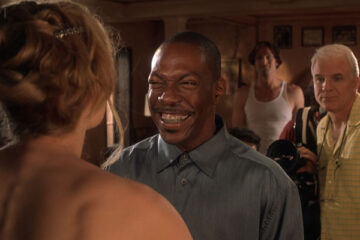 Bowfinger 1999 Movie Scene Eddie Murphy as Kit Ramsey smiling while looking at Heather Graham as Daisy with Steve Martin as Bowfinger shooting in the background