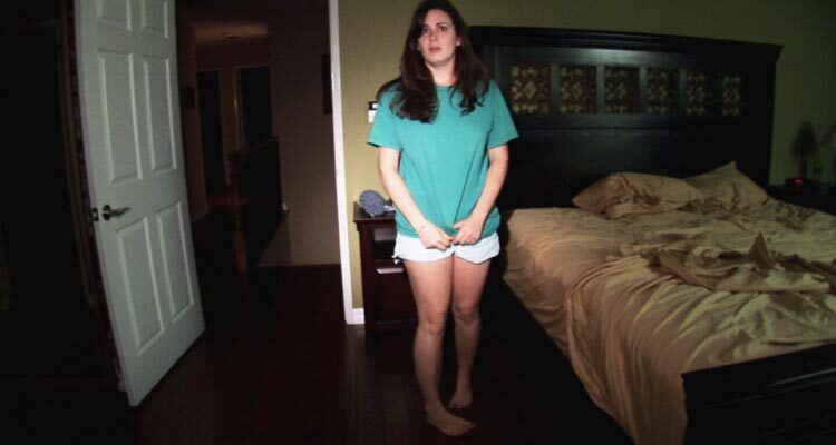 Paranormal Activity 2007 Movie Scene Katie Featherston as Katie standing in the bedroom after hearing strange sounds