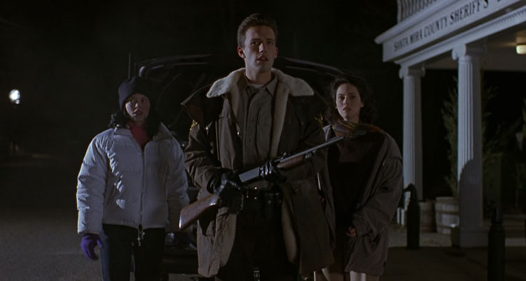 Phantoms 1998 Movie Scene Ben Affleck as Sheriff Bryce Hammond holding a shotgun with Joanna Going as Jennifer and Rose McGowan as Lisa standing behind him