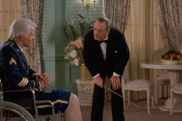 Dirty Rotten Scoundrels 1988 Movie Scene Steve Martin as Freddy Benson sitting in a wheelchair as Michael Caine as Lawrence Jamieson pretending to be Dr. Schaffhausen is a about to whip his legs