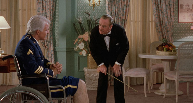 Dirty Rotten Scoundrels 1988 Movie Scene Steve Martin as Freddy Benson sitting in a wheelchair as Michael Caine as Lawrence Jamieson pretending to be Dr. Schaffhausen is a about to whip his legs