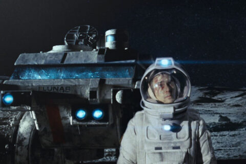 Moon Movie 2009 Scene Sam Rockwell as Sam Bell in his astronaut suit with the rover behind him walking on the surface of moon