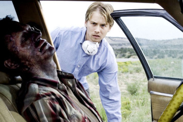 Carriers 2009 Movie Lou Taylor Pucci as Danny looking at the corpse of an infected person as he's trying to rob the car