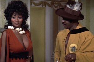 Coffy 1973 Movie Scene Pam Grier as Coffy wearing a revealing red dress and Robert DoQui as King George