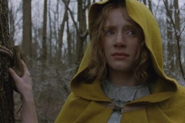 The Village 2004 Movie Scene Bryce Dallas Howard as Ivy Walker wearing a yellow cloak and standing on the edge of the woods