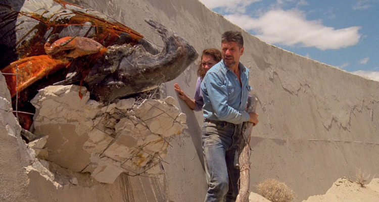 Tremors Movie 1990 Scene Fred Ward as Earl and Finn Carter as Rhonda looking at a dead graboid monster