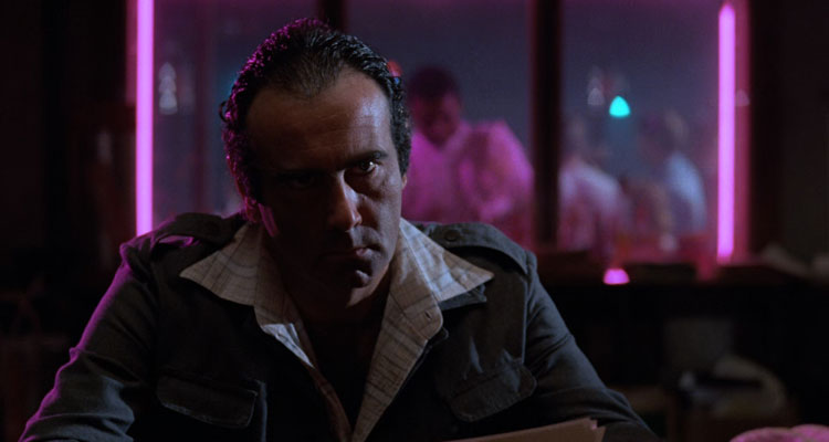 Blood Simple 1984 Movie Scene Dan Hedaya as Julian in the back of the nightclub with neon lights shining behind him