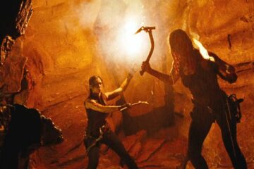 The Descent 2005 Movie Scene Shauna Macdonald as Sarah holding climbing axe and Natalie Mendoza as Juno holding a flare in a cave ready to fight