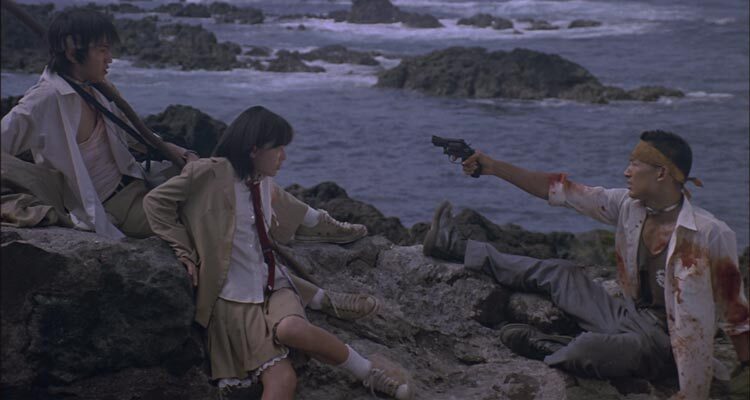 Battle Royale 2000 Movie Scene The last three students who are alive on the island with one of them holding a gun pointed at the others
