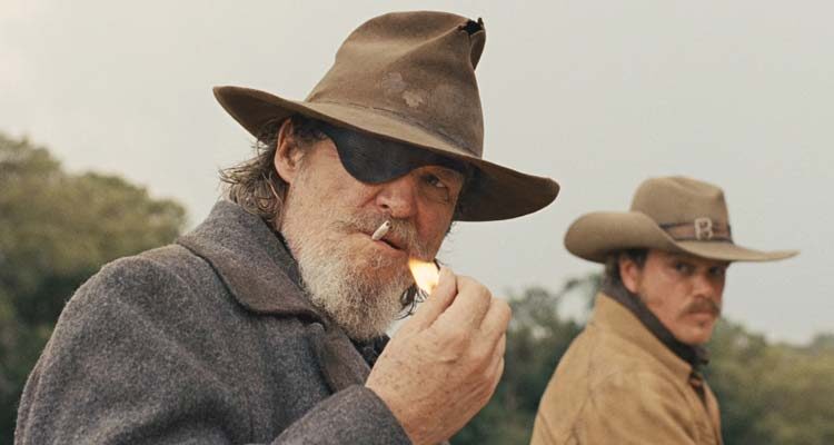 True Grit 2010 Movie Scene Jeff Bridges as Rooster Cogburn lighting up a cigarette