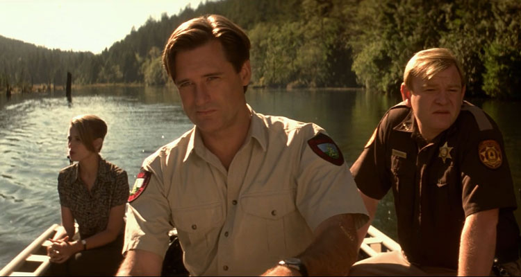 Lake Placid 1999 Movie Scene Bill Pullman as Jack driving a boat on the lake looking for the crocodile with Brendan Gleeson as Sheriff Hank and Bridget Fonda as Kelly