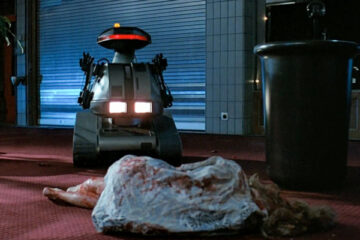 Chopping Mall 1986 Movie Scene A killer robot known as Killbot standing over the dead body of a girl who he just killed
