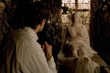Cemetery Man 1994 Movie Scene Rupert Everett as Francesco Dellamorte watching Anna Falchi as She raising from the dead covered with a white sheet