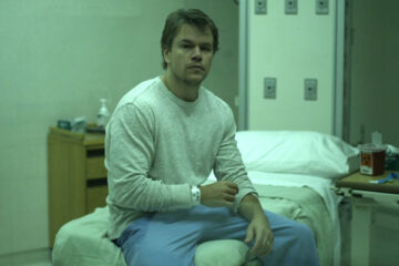 Contagion 2011 Movie Scene Matt Damon as Mitch Emhoff sitting in a hospital bed isolated after he contracted the virus