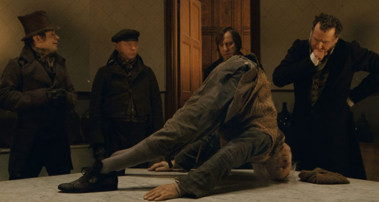 Burke and Hare 2010 Movie Scene Simon Pegg as Burke, Andy Serkis as Hare and Tom Wilkinson as Doctor Robert Knox looking at a contorted corpse on a table