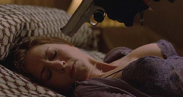 Derailed 2005 Movie Scene Jennifer Aniston as Lucinda Harris laying in bed in lingerie with a gun to her head held by Vincent Cassel as LaRoche