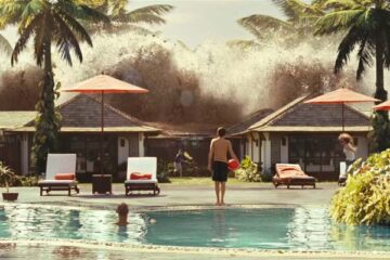 The Impossible 2012 Movie Scene A small boy holding a red ball next to a pool looking at an incoming tsunami wave hitting the resort