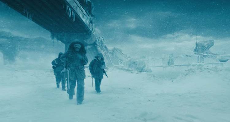 The Colony 2013 Movie Scene Three survivors walking through snow-covered post-apocalyptic wasteland under a destroyed bridge