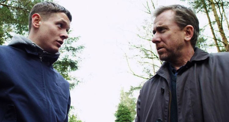 The Liability 2012 Movie Jack O'Connell and Tim Roth looking at each other in the forest scene