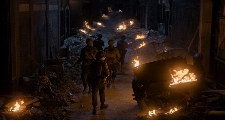 Ghosts of War 2020 Movie Brenton Thwaites, Theo Rossi, Kyle Gallner, Skylar Astin and Alan Ritchson walking through a street filled with rubble and fire on their way to the castle