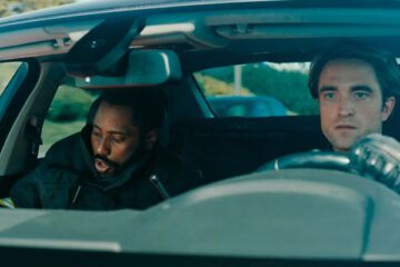 Tenet 2020 Movie John David Washington and Robert Pattinson in a car driving down the highway