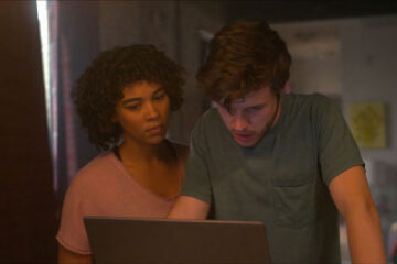Silk Road 2021 Movie Nick Robinson as Ross Ulbricht and Alexandra Shipp as Julia looking at his laptop