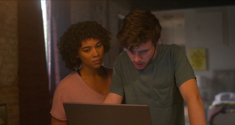 Silk Road 2021 Movie Nick Robinson as Ross Ulbricht and Alexandra Shipp as Julia looking at his laptop