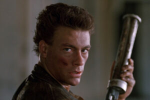 Cyborg 1989 Movie Scene Jean-Claude Van Damme as Gibson Rickenbacker holding a six-shooter and looking at the camera