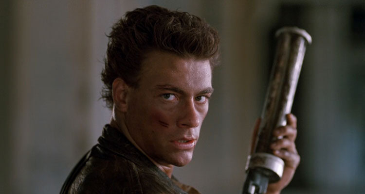 Cyborg 1989 Movie Scene Jean-Claude Van Damme as Gibson Rickenbacker holding a six-shooter and looking at the camera