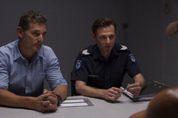 The Dry 2020 Movie Scene Eric Bana as Aaron Falk and Keir O'Donnell as Greg Raco in the interrogation room