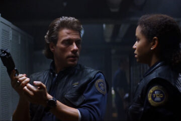 Timecop 1994 Movie Scene Jean-Claude Van Damme holding a futuristic gun and Gloria Reuben