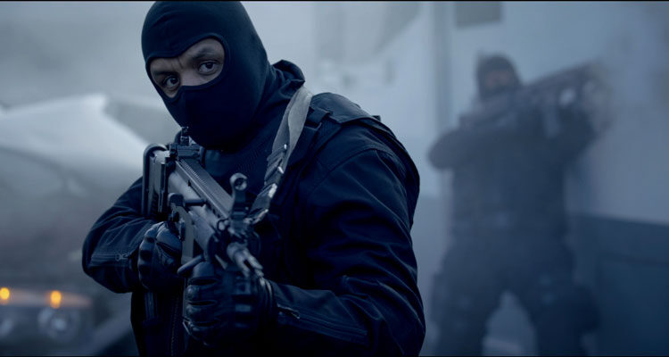 Braqueurs 2015 Movie Scene Youssef Hajdi as Nasser in full gear holding an automatic rifle
