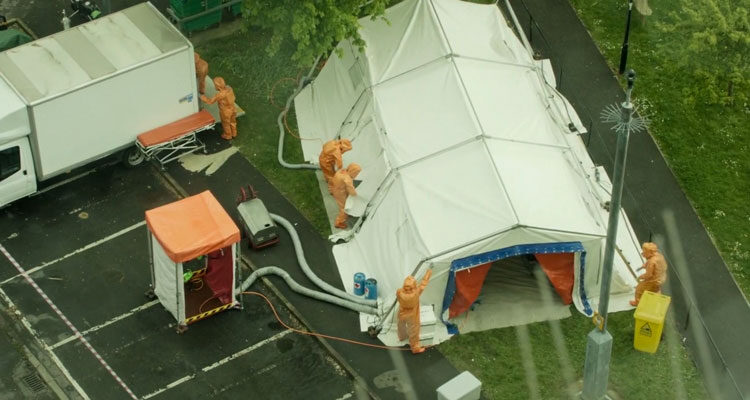 Containment 2015 Movie Scene People in orange hazmat suits setting up tents outside the apartment building