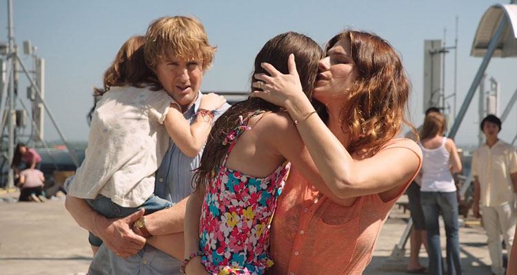 No Escape 2015 Movie Scene Lake Bell as Annie Dwyer and Owen Wilson as Jack Dwyer holding their daughters on the rooftop of hotel