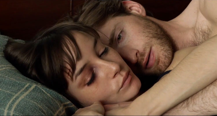 The Living 2014 Movie Scene Fran Kranz as Teddy and Jocelin Donahue as Molly laying in bed