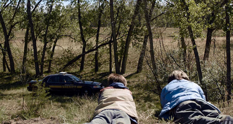 Cop Car 2015 Movie Scene Hays Wellford as Harrison and James Freedson-Jackson as Travis looking at an abandoned police car