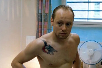 Hawaii Oslo 2004 Movie Scene Aksel Hennie as Trygve with a tattoo on his shoulder getting dressed in his cell