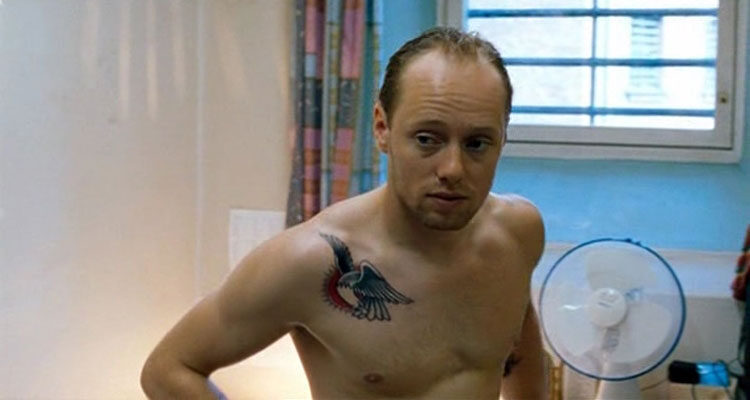 Hawaii Oslo 2004 Movie Scene Aksel Hennie as Trygve with a tattoo on his shoulder getting dressed in his cell